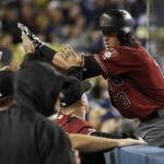 Arizona Diamondbacks' Nick Ahmed, right, celebrates with the dugout after he hits a solo home run off of Los Angeles Dodgers starting pitcher Alex Wood, not pictured, during the third inning of a baseball game in Los Angeles, Wednesday, April 13, 2016. (AP Photo/Kelvin Kuo)