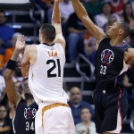 Los Angeles Clippers' Wesley Johnson (33) blocks the shot of Phoenix Suns' Alex Len (21) as Clippers' Paul Pierce (34) defends during the first half of an NBA basketball game Wednesday, April 13, 2016, in Phoenix. (AP Photo/Ross D. Franklin)