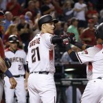 Arizona Diamondbacks' Jean Segura (2) celebrates his three-run home run against the St. Louis Cardinals with Zack Greinke (21) as Cardinals catcher Yadier Molina, left, looks on during the sixth inning of a baseball game Monday, April 25, 2016, in Phoenix. (AP Photo/Ross D. Franklin)
