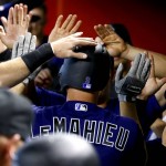 Colorado Rockies' DJ LeMahieu is greeted in the dugout after hitting a solo home run against the Arizona Diamondbacks during the third inning of a baseball game, Wednesday, April 6, 2016, in Phoenix. (AP Photo/Matt York)