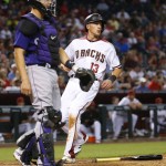 Arizona Diamondbacks' Nick Ahmed (13) scores on a ground out by David Peralta during the third inning of a baseball game as Colorado Rockies catcher Nick Hundley watches the play, Wednesday, April 6, 2016, in Phoenix. (AP Photo/Matt York)