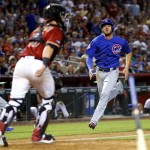 Chicago Cubs' Kris Bryant scores on an RBI hit by teammate Tommy La Stella as Arizona Diamondbacks Chris Herrmann waits for the throw during the seventh inning of a baseball game, Sunday, April 10, 2016, in Phoenix. (AP Photo/Matt York)