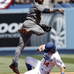 Arizona Diamondbacks second baseman Jean Segura, left, leaps after forcing out Los Angeles Dodgers' Enrique Hernandez (14), to make the relay to first, but not in time to get Yasiel Puig during the first inning of a baseball game in Los Angeles, Tuesday, April 12, 2016. (AP Photo/Alex Gallardo)