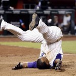 Arizona Diamondbacks' Jean Segura rolls over home plate after an inside-the-park home run against the Chicago Cubs during the second inning of a baseball game Thursday, April 7, 2016, in Phoenix. (AP Photo/Ross D. Franklin)