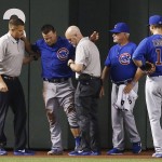 An injured Chicago Cubs' Kyle Schwarber, second from left, is attended to by training staff as manager Joe Maddon, second from right, and Ben Zobrist (18) look on during the second inning of a baseball game against the Arizona Diamondbacks Thursday, April 7, 2016, in Phoenix. (AP Photo/Ross D. Franklin)