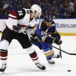 Arizona Coyotes' Jiri Sekac, left, of the Czech Republic, and St. Louis Blues' Kyle Brodziak reach for a loose puck during the first period of an NHL hockey game Monday, April 4, 2016, in St. Louis. (AP Photo/Billy Hurst)