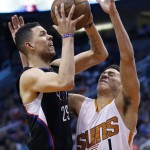 Los Angeles Clippers' Austin Rivers (25) drives past Phoenix Suns' Devin Booker (1) and delivers an elbow to Booker's face, during the first half of an NBA basketball game Wednesday, April 13, 2016, in Phoenix. (AP Photo/Ross D. Franklin)