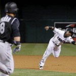 Colorado Rockies' Gerardo Parra (8) runs down to first base as he beats the glove toss by Arizona Diamondbacks' Jean Segura, right, for an infield single during the fourth inning of a baseball game Tuesday, April 5, 2016, in Phoenix. (AP Photo/Ross D. Franklin)