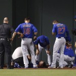 An injured Chicago Cubs Kyle Schwarber remains still on the field as training staff attends to him, manager Joe Maddon, middle, talks to Schwarber and teammates Ben Zobrist (18), Addison Russell (27), Anthony Rizzo (44), Kris Bryant (17), and Jason Heyward, second from right, look on during the second inning of a baseball game against the Arizona Diamondbacks Thursday, April 7, 2016, in Phoenix. (AP Photo/Ross D. Franklin)