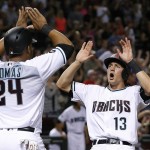 Arizona Diamondbacks' Nick Ahmed (13) and Yasmany Tomas (24) celebrate as both scored on a triple by Jean Segura during the sixth inning of a baseball game against the Colorado Rockies Tuesday, April 5, 2016, in Phoenix. (AP Photo/Ross D. Franklin)