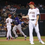 Colorado Rockies Trevor Story (27) rounds the bases after hitting a two RBI home run as Arizona Diamondbacks starting pitcher Patrick Corbin (46) waits for the ball during the first inning of a baseball game, Wednesday, April 6, 2016, in Phoenix. (AP Photo/Matt York)