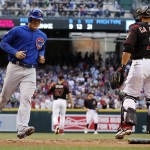 Chicago Cubs' Anthony Rizzo, left, scores a run as Arizona Diamondbacks catcher Welington Castillo, right, watches during the first inning of a baseball game Saturday, April 9, 2016, in Phoenix. (AP Photo/Ross D. Franklin)