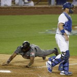 Arizona Diamondbacks' Socrates Brito, left, scores past Los Angeles Dodgers catcher A.J. Ellis on a ground out by David Peralta during sixth inning of a baseball game in Los Angeles, Thursday, April 14, 2016. (AP Photo/Chris Carlson)