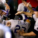 Colorado Rockies shortstop Trevor Story (27) is greeted in the dugout after hitting his first career home run during the third inning of a baseball game against the Arizona Diamondbacks, Monday, April 4, 2016, in Phoenix. (AP Photo/Matt York)