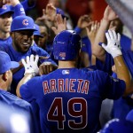 Chicago Cubs Jake Arrieta (49) is greeted in the dugout by teammates after hitting a two-run home run against the Arizona Diamondbacks during the second inning of a baseball game, Sunday, April 10, 2016, in Phoenix. (AP Photo/Matt York)