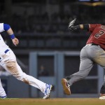 Los Angeles Dodgers' Joc Pederson,  left, runs to third base after a throwing error on Arizona Diamondbacks shortstop Nick Ahmed to second baseman Jean Segura, right, during the fifth inning of a baseball game in Los Angeles, Wednesday, April 13, 2016. (AP Photo/Kelvin Kuo)