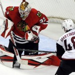 Chicago Blackhawks goalie Scott Darling (33) makes a save off of his mask from a shot by Arizona Coyotes left wing Jordan Martinook (48) in the third period of an NHL hockey game Tuesday, April 5, 2016, in Chicago. The Blackhawks won 6-2. (AP Photo/David Banks)