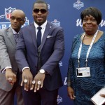 Alabama's Reggie Ragland, center, shows off his national championship rings as he poses for photos upon arriving for the first round of the 2016 NFL football draft at the Auditorium Theater of Roosevelt University, Thursday, April 28, 2016, in Chicago. (AP Photo/Nam Y. Huh)