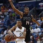 New Orleans Pelicans guard Tim Frazier (2) passes around Phoenix Suns guard Ronnie Price (14) in the first half of an NBA basketball game in New Orleans, Saturday, April 9, 2016. (AP Photo/Gerald Herbert)