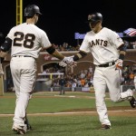 San Francisco Giants' Joe Panik, right, is congratulated by Buster Posey (28) after hitting a solo home run against the Arizona Diamondbacks during the fifth inning of a baseball game in San Francisco, Monday, April 18, 2016. (AP Photo/Jeff Chiu)
