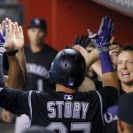 Colorado Rockies' Trevor Story, left, celebrates his home run against the Arizona Diamondbacks with teammates, including Nick Hundley, right, during the fourth inning of a baseball game Tuesday, April 5, 2016, in Phoenix. (AP Photo/Ross D. Franklin)