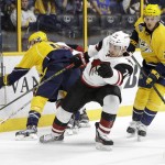 Arizona Coyotes center Laurent Dauphin (76) battles for the puck with Nashville Predators defensemen Ryan Ellis (4) and Anthony Bitetto (2) in the first period of an NHL hockey game Thursday, April 7, 2016, in Nashville, Tenn. (AP Photo/Mark Humphrey)