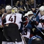 Members of the Arizona Coyotes and San Jose Sharks push each other against the boards during the third period of an NHL hockey game Saturday, April 9, 2016, in San Jose, Calif. San Jose won 1-0. (AP Photo/Marcio Jose Sanchez)