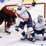 Washington Capitals' Philipp Grubauer, right, of Germany, makes a save as Capitals' Matt Niskanen (2) sends Arizona Coyotes' Viktor Tikhonov (9), of Russia, into the net during the second period of an NHL hockey game Saturday, April 2, 2016, in Glendale, Ariz. (AP Photo/Ross D. Franklin)