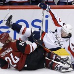 Washington Capitals' T.J. Oshie (77) falls over Arizona Coyotes' Kyle Chipchura (24) during the third period of an NHL hockey game Saturday, April 2, 2016, in Glendale, Ariz. The Coyotes defeated the Capitals 3-0. (AP Photo/Ross D. Franklin)