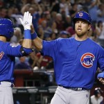 Chicago Cubs' Ben Zobrist, right, gets a high-five from teammate Tommy La Stella after Zobrist scored against the Arizona Diamondbacks during the third inning of a baseball game Thursday, April 7, 2016, in Phoenix. (AP Photo/Ross D. Franklin)