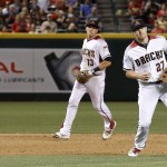 Arizona Diamondbacks' Brandon Drury (27) fails to make a play on a grounder hit by St. Louis Cardinals' Stephen Piscotty as Diamondbacks' Nick Ahmed (13) looks on during the fifth inning of a baseball game Monday, April 25, 2016, in Phoenix. A run scored on the Piscotty infield single. (AP Photo/Ross D. Franklin)