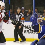 St. Louis Blues goalie Brian Elliott, right, makes a glove save as Arizona Coyotes' Brad Richardson swats for the puck during the first period of an NHL hockey game Monday, April 4, 2016, in St. Louis. (AP Photo/Billy Hurst)