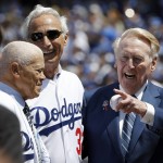 Los Angeles Dodgers broadcaster Vin Scully, right, points to another former player, with Sandy Koufax, center, and Maury Wills, left, before the start of an opening day baseball game between the Los Angeles Dodgers and Arizona Diamondbacks in Los Angeles, Tuesday, April 12, 2016. (AP Photo/Alex Gallardo)