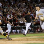 Arizona Diamondbacks' Yasmany Tomas,second from right, scores on an error by Pittsburgh Pirates' David Freese as Pirates catcher Francisco Cervelli (29) waits for the throw during the eighth inning of a baseball game, Saturday, April 23, 2016, in Phoenix. (AP Photo/Matt York)