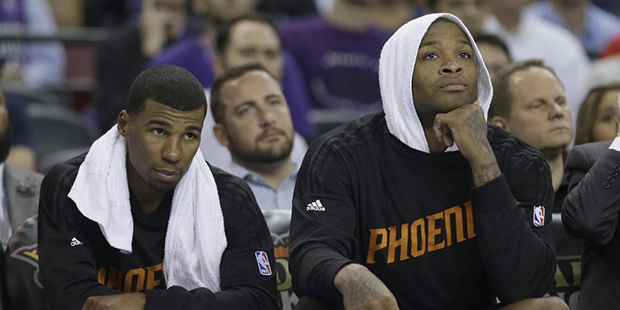 Phoenix Suns' Ronnie Price, left, and P.J. Tucker watch the closing moments of the Suns 116-94 loss...