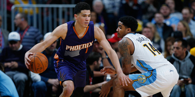 Phoenix Suns guard Devin Booker, left, drives past Denver Nuggets guard Gary Harris during the seco...