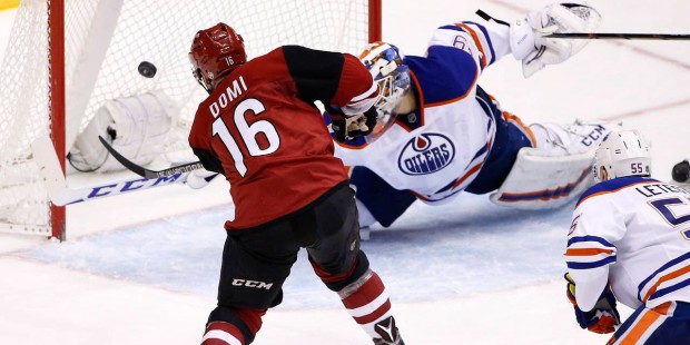 Arizona Coyotes' Max Domi (16) scores a goal on Edmonton Oilers' Anders Nilsson, top right, of Swed...