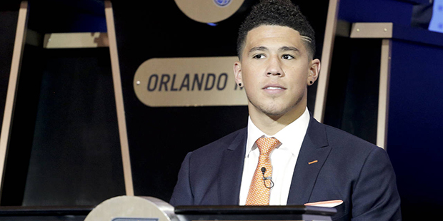 Phoenix Suns guard Devin Booker listens as the results of the NBA basketball draft lottery are anno...
