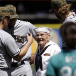 World War II veteran Burke Waldron wears a U.S. Navy uniform as he greets members of the San Diego Padres before a baseball game against the Seattle Mariners on Monday, May 30, 2016, in Seattle. Waldron also threw out the ceremonial first pitch, as part of Memorial Day ceremonies at the game. (AP Photo/Elaine Thompson)