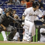 Miami Marlins' Christian Yelich, right, watches after grounding into a fielder's choice as J.T. Realmuto scores during the first inning of a baseball game, Tuesday, May 3, 2016, in Miami against the Arizona Diamondbacks. At left is Arizona Diamondbacks catcher Welington Castillo. (AP Photo/Lynne Sladky)