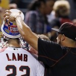Arizona Diamondbacks' Jake Lamb, left, gets a bucket of candy and ice dumped on his head by teammate David Peralta, right, after a baseball game Monday, May 16, 2016, in Phoenix. Diamondbacks' Lamb connected for a three-run homer and the Diamondbacks defeated the Yankees 12-2. (AP Photo/Ross D. Franklin)