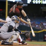 Arizona Diamondbacks' Paul Goldschmidt, top, reaches out on a swing for a double as San Diego Padres' Derek Norris, second from left, and umpire Todd Tichenor watch during the first inning of a baseball game Saturday, May 28, 2016, in Phoenix. (AP Photo/Ross D. Franklin)