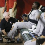 New York Yankees' Didi Gregorius is worked on by head athletic trainer Steve Donohue, left, after Gregorius was hit by a line drive while running the bases during the second inning of a baseball game against the Arizona Diamondbacks on Wednesday, May 18, 2016, in Phoenix. Gregorius remained in the game. (AP Photo/Ross D. Franklin)