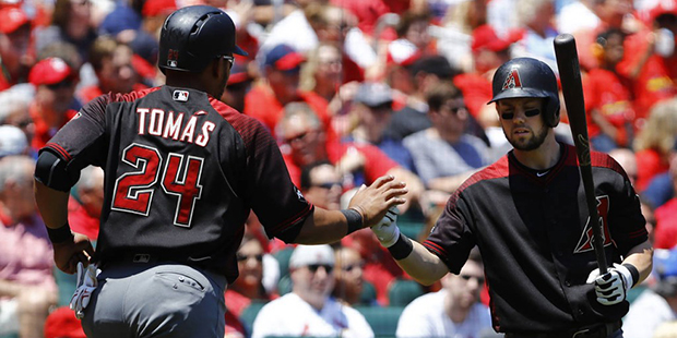 Arizona Diamondbacks' Yasmany Tomas is congratulated by Chris Owings, right, after scoring on a sin...