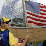 Nick Comito, foreground, with Mitch Bell, both of Greensburg, Pa., waves the U.S. Flag on Memorial Day as they wait outside the Consol Energy Center for Game 1 of the Stanley Cup final series between the San Jose Sharks and the Pittsburgh Penguins on Monday, May 30, 2016, in Pittsburgh. (AP Photo/Gene J. Puskar)