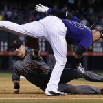 Colorado Rockies' Trevor Story, front, is tagged out while trying to stretch a double into a triple at third base by Arizona Diamondbacks third baseman Jake Lamb to end the fourth inning of a baseball game, Monday, May 9, 2016, in Denver. Story drove in two runs with the hit. (AP Photo/David Zalubowski)