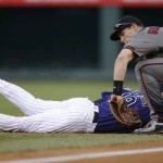 Colorado Rockies' Charlie Blackmon, left, dives back into first base as Arizona Diamondbacks first baseman Paul Goldschmidt fields the pickoff attempt in the first inning of a baseball game Monday, May 9, 2016, in Denver. (AP Photo/David Zalubowski)