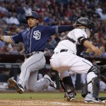 San Diego Padres' Jon Jay, left, leaps to home plate to score as Arizona Diamondbacks' Welington Castillo waits for a late throw during the third inning of a baseball game Friday, May 27, 2016, in Phoenix. (AP Photo/Ross D. Franklin)