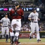 New York Yankees' Jacoby Ellsbury, right, arrives at home plate to score a run after a two-run home run by Brett Gardner, left, as Arizona Diamondbacks' Welington Castillo, middle, watches during the first inning of a baseball game Wednesday, May 18, 2016, in Phoenix. (AP Photo/Ross D. Franklin)