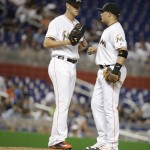 Miami Marlins starting pitcher Justin Nicolino, left, talks with second baseman Miguel Rojas, right, during the fourth inning of a baseball game against the Arizona Diamondbacks, Tuesday, May 3, 2016, in Miami. (AP Photo/Lynne Sladky)